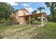 Charming two-story home with a covered parking area, surrounded by lush greenery at 27113 Robertson Rd, Yalaha, FL 34797