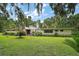 Charming single-story home featuring a lush green lawn and mature landscaping, offering serene curb appeal at 27113 Robertson Rd, Yalaha, FL 34797