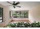 Sunroom with large windows showcasing garden views and a ceiling fan at 27113 Robertson Rd, Yalaha, FL 34797