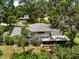 Aerial view of home surrounded by mature trees and lush greenery at 27212 Orange Ave, Yalaha, FL 34797