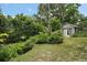 Landscaped backyard featuring lush greenery and a storage shed at 27212 Orange Ave, Yalaha, FL 34797