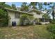 The fenced backyard is framed by lush trees and shrubbery, with a screened porch at the back of the home at 27212 Orange Ave, Yalaha, FL 34797