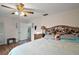 Comfortable bedroom features a ceiling fan, wood floor, and a cozy headboard at 27212 Orange Ave, Yalaha, FL 34797