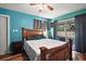 Cozy bedroom with a rustic wood bed frame, gray curtains, and lots of natural light at 27212 Orange Ave, Yalaha, FL 34797