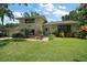 Charming two-story home with a well-manicured lawn, mature trees and a brick facade at 27212 Orange Ave, Yalaha, FL 34797