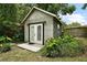 Charming outbuilding featuring double doors, gray exterior, and neat surrounding landscape at 27212 Orange Ave, Yalaha, FL 34797
