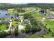 Expansive aerial view of a neighborhood highlighting waterfront homes, ponds, and ample green space at 29152 David Ct, Tavares, FL 32778