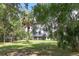 Large, lush backyard shaded by mature trees and featuring a screened-in porch at 29152 David Ct, Tavares, FL 32778