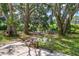 Spacious backyard features mature trees, lush greenery, and a charming pathway leading to the waterfront at 29152 David Ct, Tavares, FL 32778