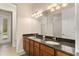 Bright bathroom featuring a double vanity with dark countertops and wood cabinets at 29152 David Ct, Tavares, FL 32778