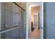 Walk-in shower features tiled walls and a glass door; hallway leads to other rooms at 29152 David Ct, Tavares, FL 32778