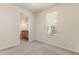 Comfortable bedroom with neutral carpet, window with blinds, and view to the adjacent bathroom at 29152 David Ct, Tavares, FL 32778