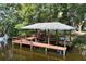 Wooden dock with covered area, railings, and steps leads down to the water, perfect for boating and enjoying lake views at 29152 David Ct, Tavares, FL 32778