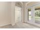 Inviting entryway with neutral carpet, arched doorway, and view to the outdoor patio through glass doors at 29152 David Ct, Tavares, FL 32778