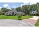 Well-maintained home with manicured lawn, mature trees, and circular driveway at 29152 David Ct, Tavares, FL 32778