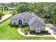 Aerial view showcases a well-maintained home with lush landscaping and backyard pond at 29152 David Ct, Tavares, FL 32778