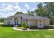 Charming stucco home featuring a manicured lawn, arched windows, and a double door entry at 29152 David Ct, Tavares, FL 32778