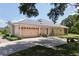 Home with large garage, well-maintained landscaping, and spacious driveway at 29152 David Ct, Tavares, FL 32778