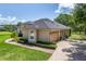 Well-maintained home exterior with manicured landscaping, brick pathway, and attached two-car garage at 29152 David Ct, Tavares, FL 32778