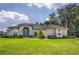 Spacious home with a well-manicured lawn, lush greenery, and charming architectural details at 29152 David Ct, Tavares, FL 32778