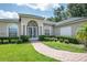 Beautiful home with landscaped yard, brick walkway, and a striking arched entryway at 29152 David Ct, Tavares, FL 32778