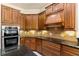 Close-up of kitchen with granite counters, tile backsplash, and built-in stainless steel oven at 29152 David Ct, Tavares, FL 32778