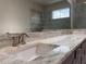 Close-up of bathroom vanity showcasing marble countertops and dual sinks, with a glimpse of the walk-in shower at 3021 King Palm Dr, New Smyrna Beach, FL 32168