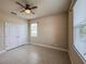 Bedroom with tile floor, double closet doors, ceiling fan and two windows at 3021 King Palm Dr, New Smyrna Beach, FL 32168