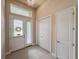Bright foyer with double front doors, tile flooring, transom window, closet and chandelier, and neutral tones at 3021 King Palm Dr, New Smyrna Beach, FL 32168