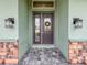 Elegant double front door with glass panels, flanked by stylish lanterns and accented by stone columns at 3021 King Palm Dr, New Smyrna Beach, FL 32168