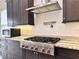 Modern kitchen features stainless steel KitchenAid gas range, hood, pot filler, mosaic backsplash, and granite counters at 3021 King Palm Dr, New Smyrna Beach, FL 32168