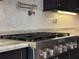 Kitchen features stainless steel KitchenAid gas range, mosaic backsplash, granite counters, and pot filler at 3021 King Palm Dr, New Smyrna Beach, FL 32168