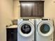 Neat laundry room with sink, Whirlpool washer and dryer, overhead cabinets, and ample space for convenience at 3021 King Palm Dr, New Smyrna Beach, FL 32168