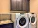 Functional laundry room with a sink, Whirlpool washer and dryer, and cabinets for storage solutions at 3021 King Palm Dr, New Smyrna Beach, FL 32168