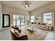 Staged living room with neutral paint, tile floors, ceiling fan, and views of the pool at 3021 King Palm Dr, New Smyrna Beach, FL 32168