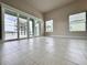 Open floor plan living room with tile floors, neutral paint, and exterior views at 3021 King Palm Dr, New Smyrna Beach, FL 32168