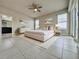 Spacious staged main bedroom with tile floors, ceiling fan, ensuite and walk in closet at 3021 King Palm Dr, New Smyrna Beach, FL 32168