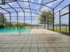Enclosed screened pool, patio, and a view of the lake provides the perfect spot for relaxation and outdoor enjoyment at 3021 King Palm Dr, New Smyrna Beach, FL 32168