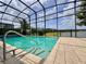Lush greenery surrounds the screened pool offering a refreshing escape and a serene view of the lake beyond at 3021 King Palm Dr, New Smyrna Beach, FL 32168