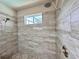 Modern walk-in shower featuring sleek tile walls, dual shower heads, and a window for natural light at 3021 King Palm Dr, New Smyrna Beach, FL 32168