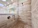 Luxurious tiled walk-in shower with modern fixtures and pebbled floor at 3021 King Palm Dr, New Smyrna Beach, FL 32168