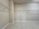 Spacious walk-in closet featuring neutral walls, tiled floors and shelving for optimal storage solutions at 3021 King Palm Dr, New Smyrna Beach, FL 32168