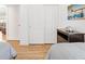 Bedroom with wood floors, closet doors, and a decorative shelf with artwork, adding charm to the space at 3331 Overland Ter, The Villages, FL 32163