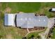 Aerial view of a single-Gathering home featuring a large roof, outbuilding, and well-maintained landscaping at 38314 Echols Rd, Leesburg, FL 34788
