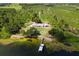 Aerial view of a waterfront home with private dock nestled among lush greenery and natural beauty at 38314 Echols Rd, Leesburg, FL 34788