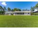 Large grassy backyard featuring a screened-in porch and covered parking at 38314 Echols Rd, Leesburg, FL 34788