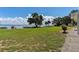 Spacious lawn leading to lakefront access, framed by mature trees and blue skies at 38314 Echols Rd, Leesburg, FL 34788