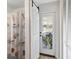 Hallway featuring barn door, leading to a bathroom, with a view to the porch at 38314 Echols Rd, Leesburg, FL 34788