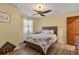 Bedroom with wood flooring, ceiling fan, a wooden door, and natural light from the window at 38314 Echols Rd, Leesburg, FL 34788