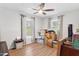 Bright bedroom featuring a ceiling fan, hardwood floors and two large windows overlooking a nice yard at 38314 Echols Rd, Leesburg, FL 34788